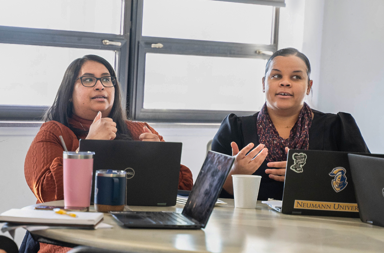 two ladies attending a conference with laptop